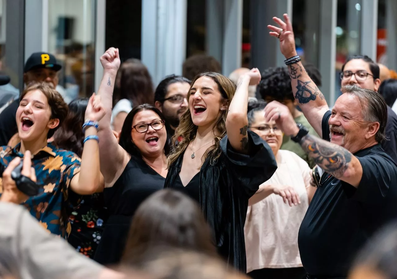 A graduate celebrating after her ceremony with her family.
