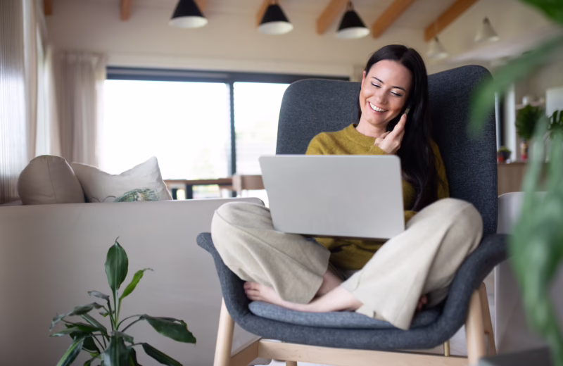 Female freelancer working from home, making phone call with client.