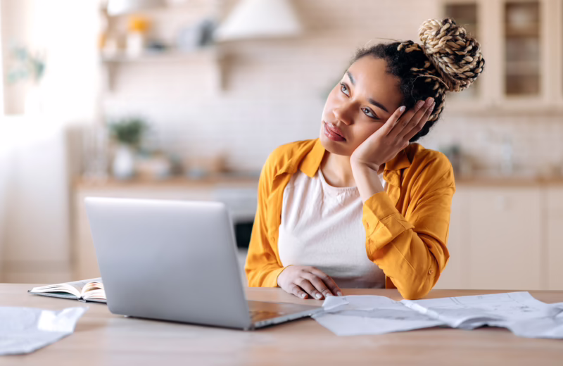 Adult learner studying online at home while working through coursework and daily responsibilities.
